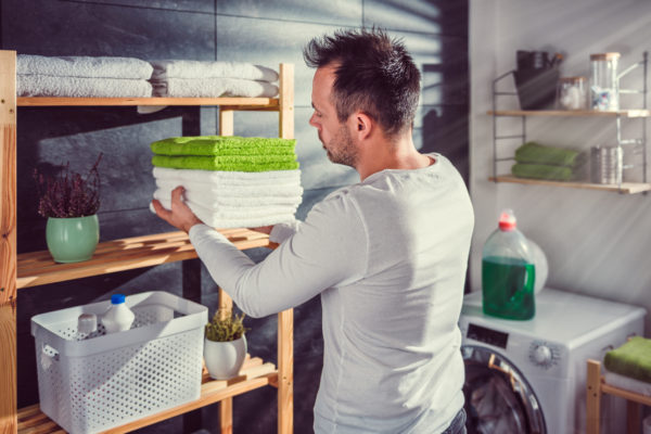 Men arranging clean towels at laundry room